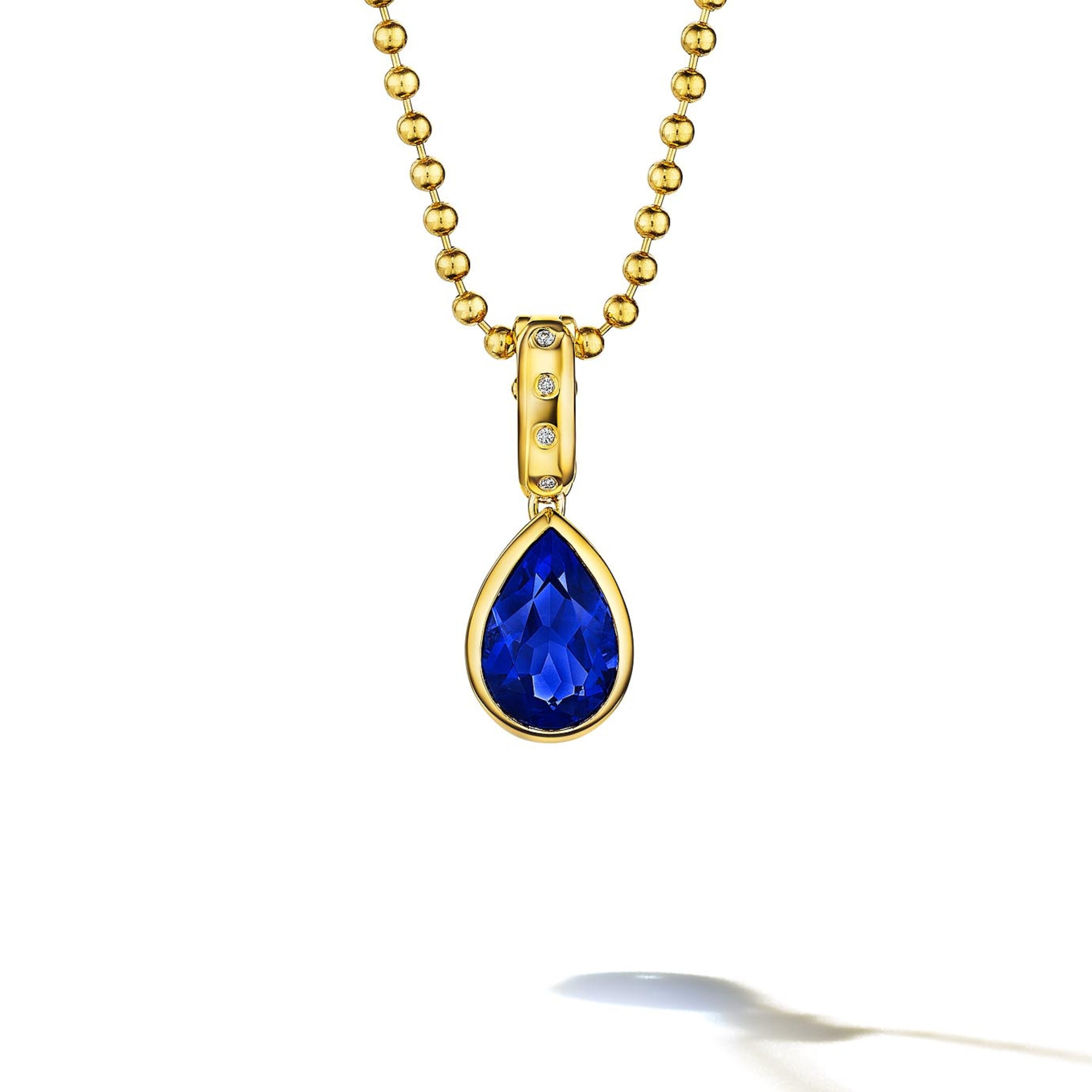 MoAnA LUU Dlo pear-shaped blue sapphire pendant in 18K yellow gold with diamonds, featuring a cane-woven frame inspired by traditional Caribbean fish traps, reflecting the house’s vision of Creole-inspired fine jewelry crafted in New York.