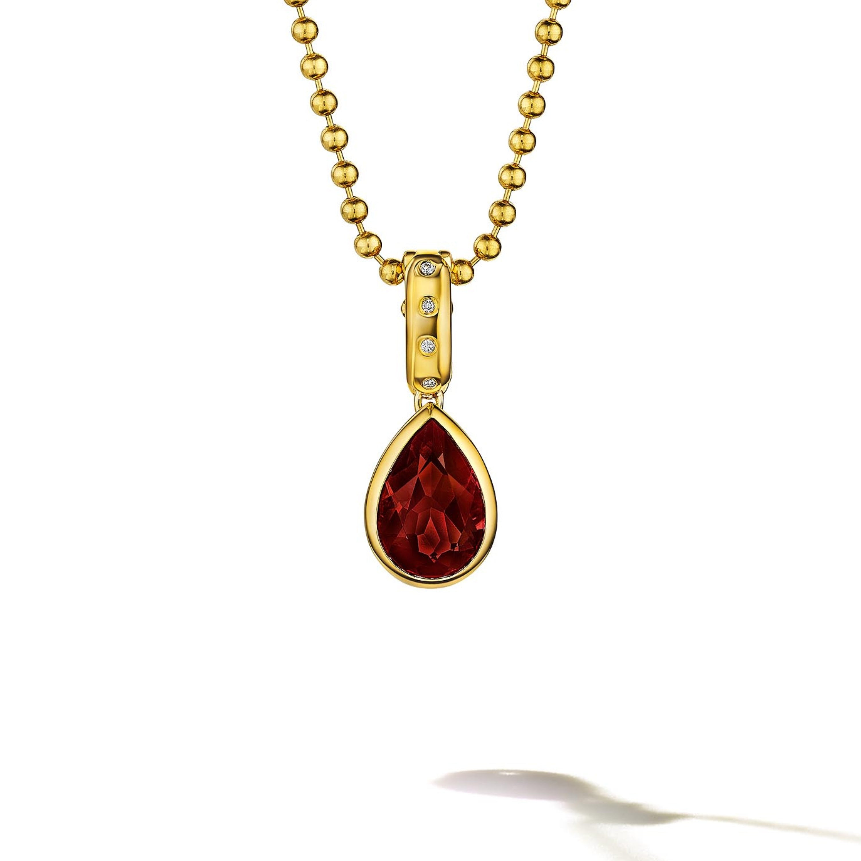 MoAnA LUU Dlo pear-shaped garnet pendant in 18K yellow gold, featuring a cane-woven frame inspired by traditional Caribbean fish traps, reflecting the house’s vision of Creole-inspired fine jewelry crafted in New York.