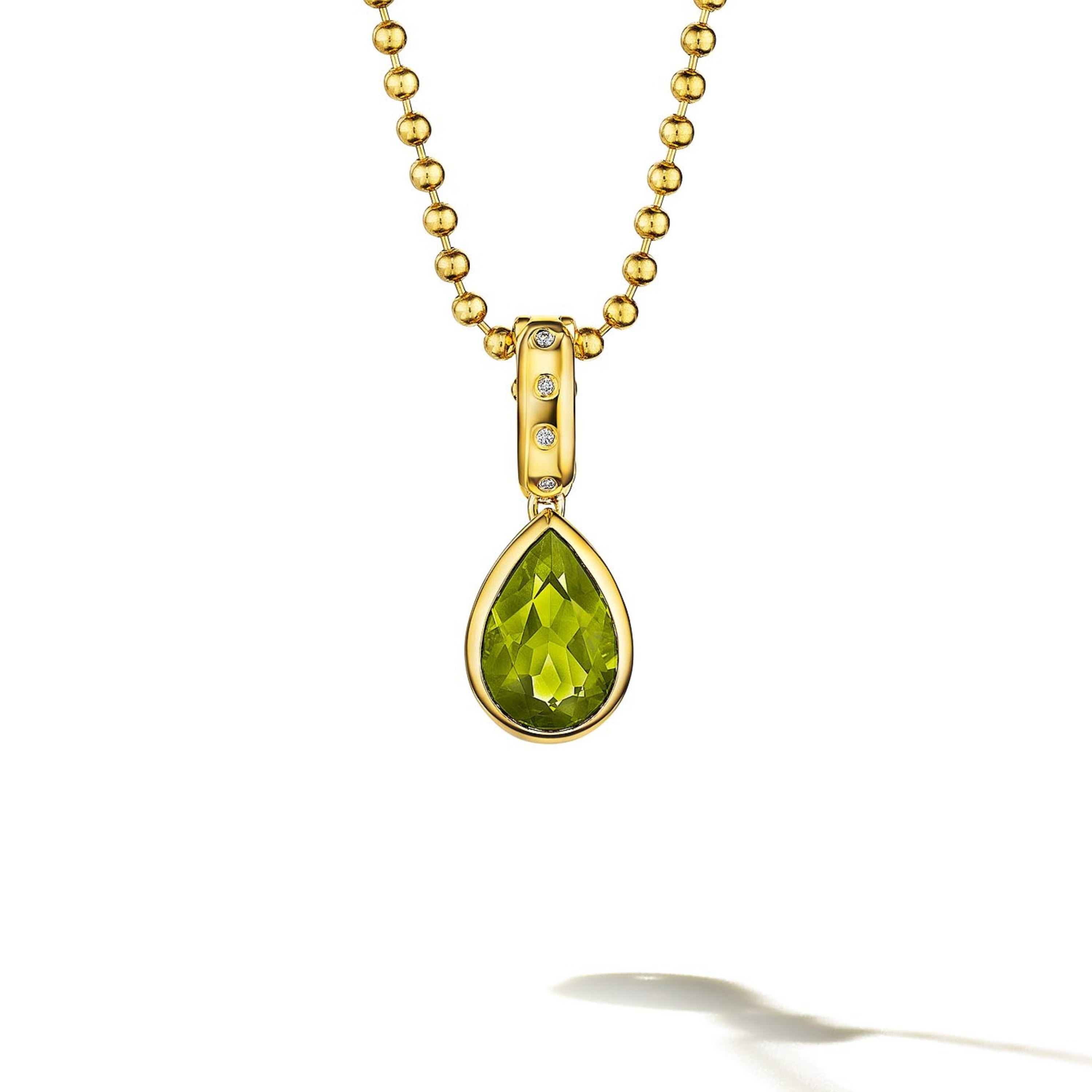 MoAnA LUU Dlo pear-shaped peridot pendant in 18K yellow gold, featuring a cane-woven frame inspired by traditional Caribbean fish traps, reflecting the house’s vision of Creole-inspired fine jewelry crafted in New York.