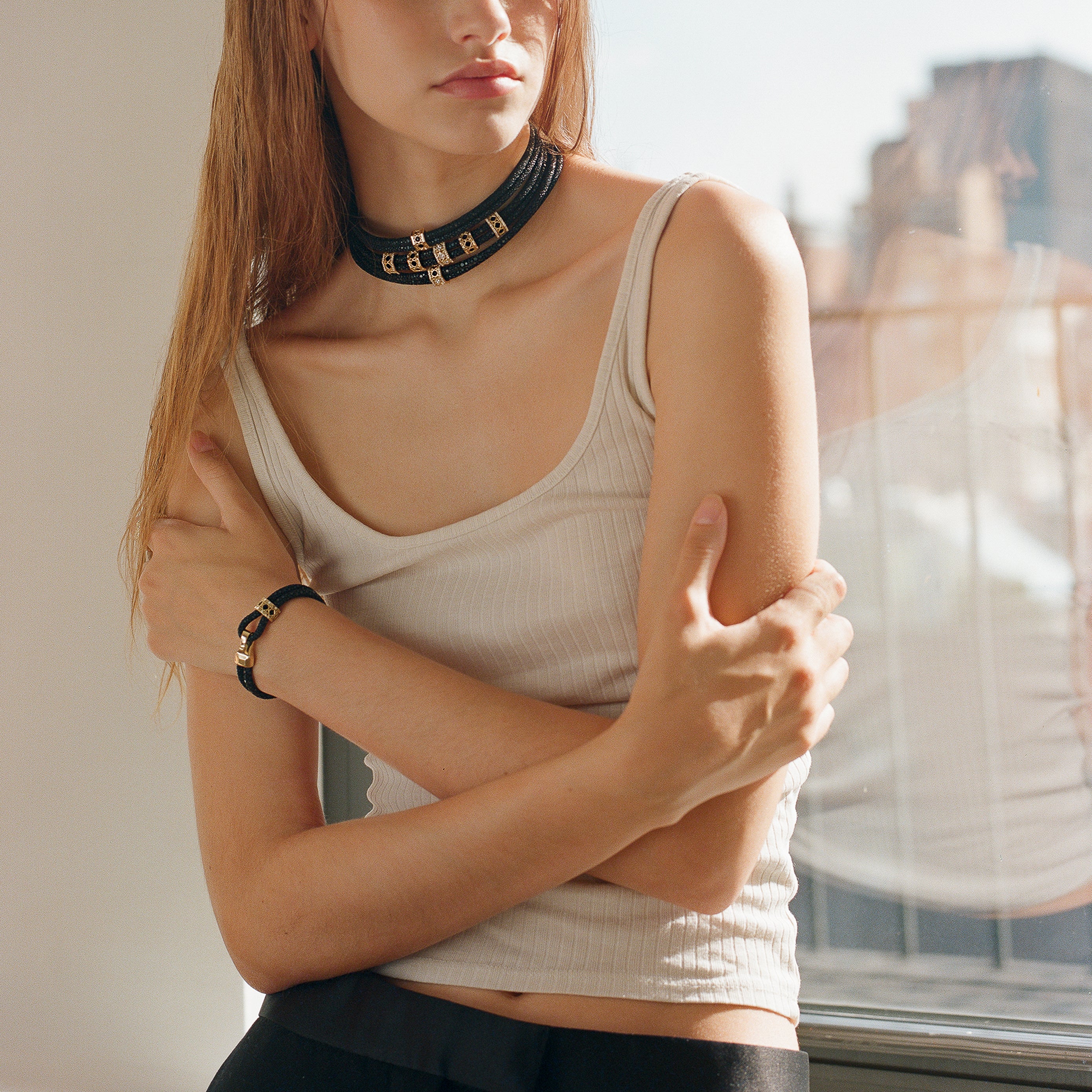 MoAnA LUU fine jewelry worn on model, featuring Abyss stingray leather chokers and bracelet with 18K yellow gold elements inspired by Caribbean fish traps.