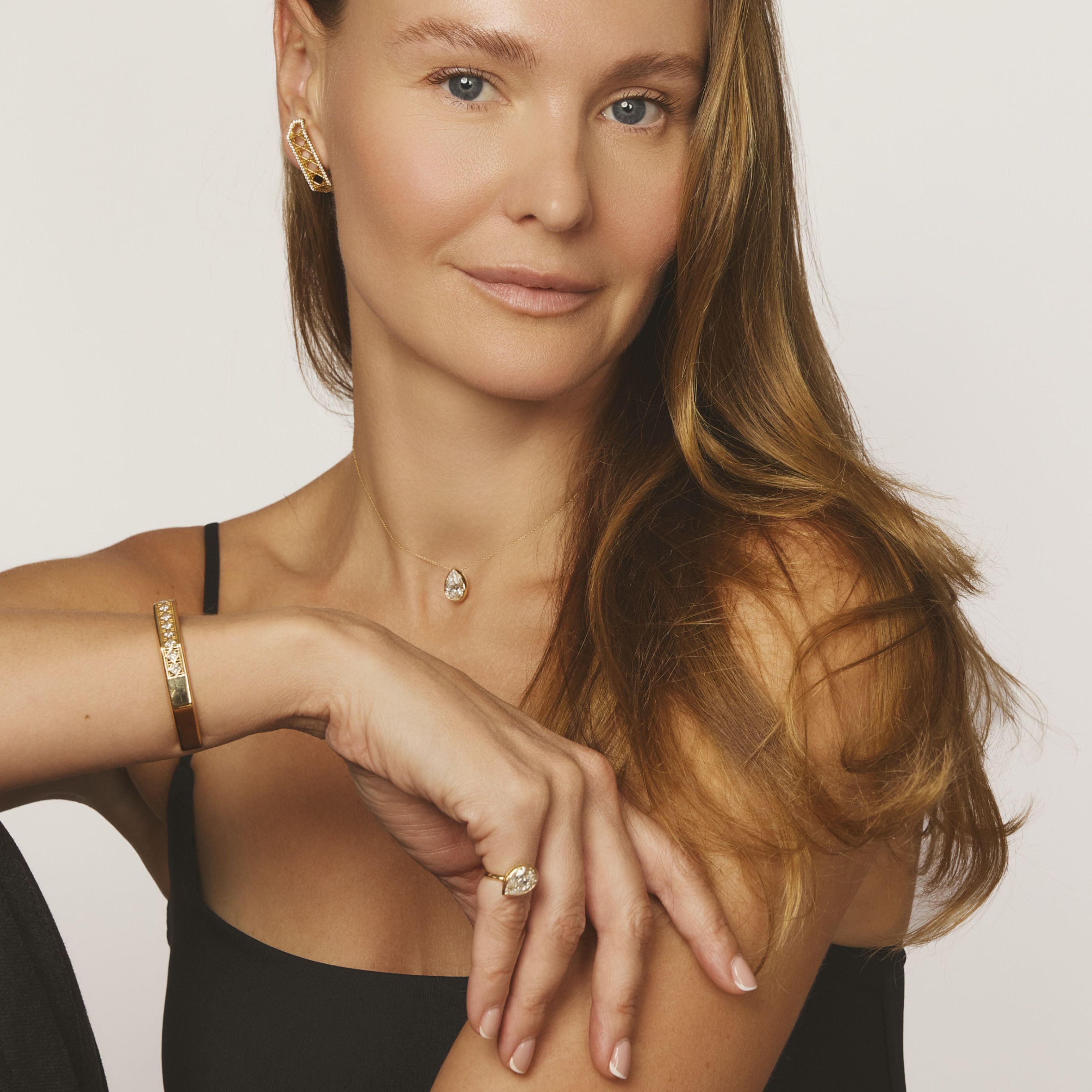 MoAnA LUU Dlo pendant and Dlo ring worn on hand, showcasing sculptural pear-shaped gem and cane woven design inspired by Caribbean heritage.