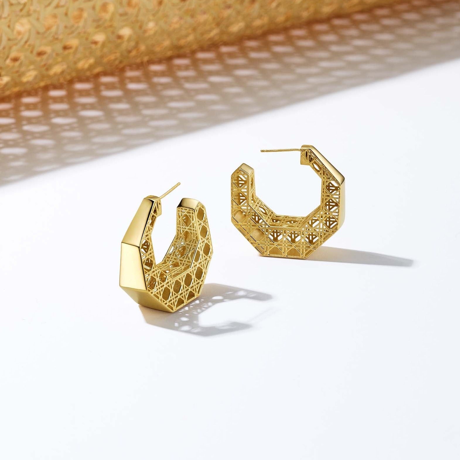 MoAnA LUU Doudou hoop earrings in 18K yellow gold, featuring an intricate woven openwork design inspired by Caribbean fish traps.