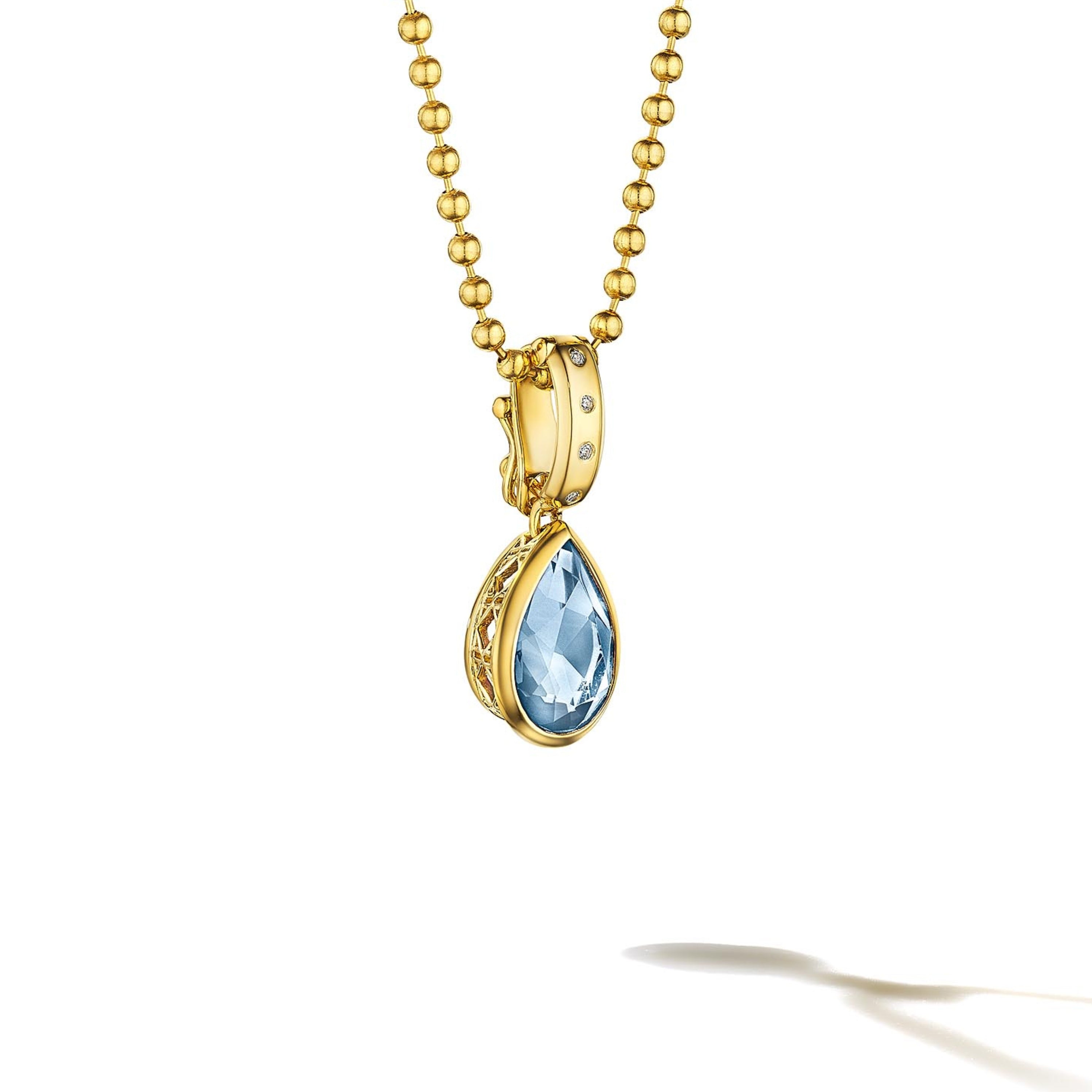 MoAnA LUU Dlo pear-shaped aquamarine pendant in 18K yellow gold, featuring a cane-woven frame inspired by traditional Caribbean fish traps, reflecting the house’s vision of Creole-inspired fine jewelry crafted in New York.