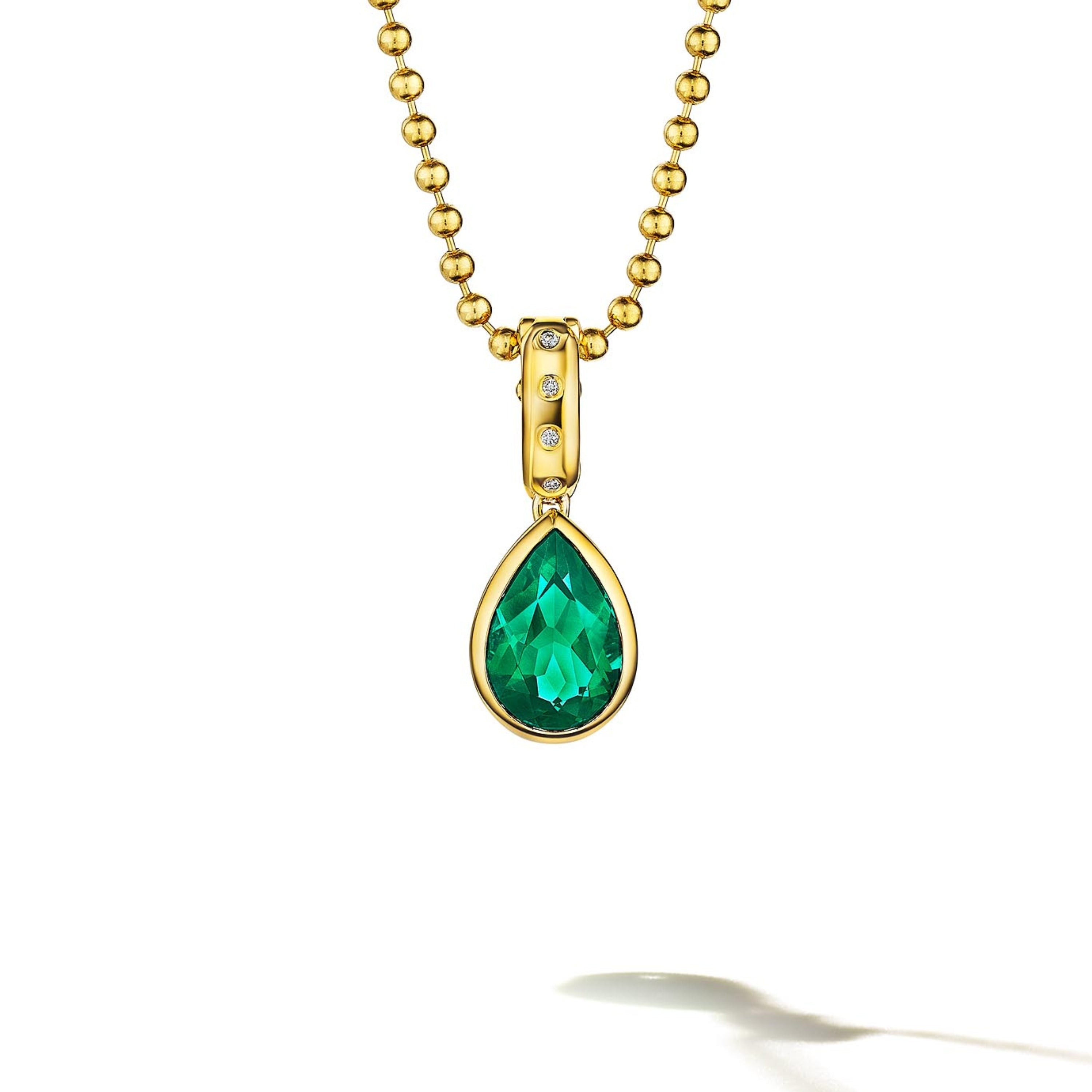 MoAnA LUU Dlo pear-shaped emerald pendant in 18K yellow gold, featuring a cane-woven frame inspired by traditional Caribbean fish traps, reflecting the house’s vision of Creole-inspired fine jewelry crafted in New York.