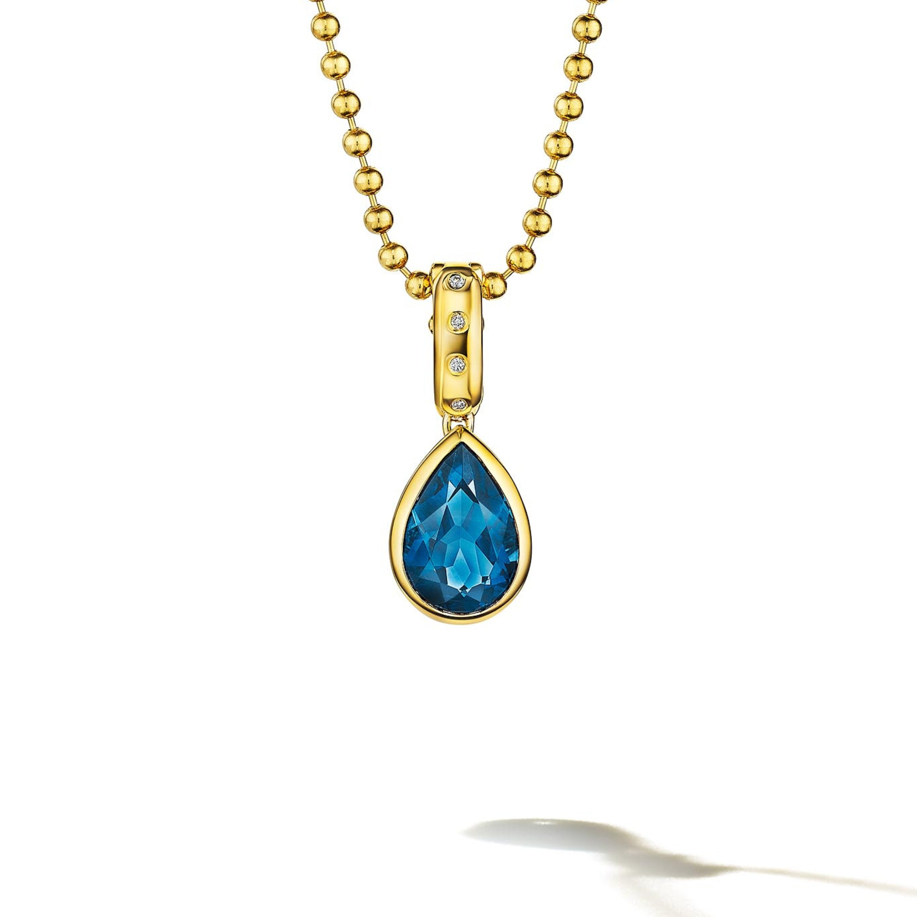 MoAnA LUU Dlo pear-shaped London blue topaz pendant in 18K yellow gold, featuring a cane-woven frame inspired by traditional Caribbean fish traps, reflecting the house’s vision of Creole-inspired fine jewelry crafted in New York.
