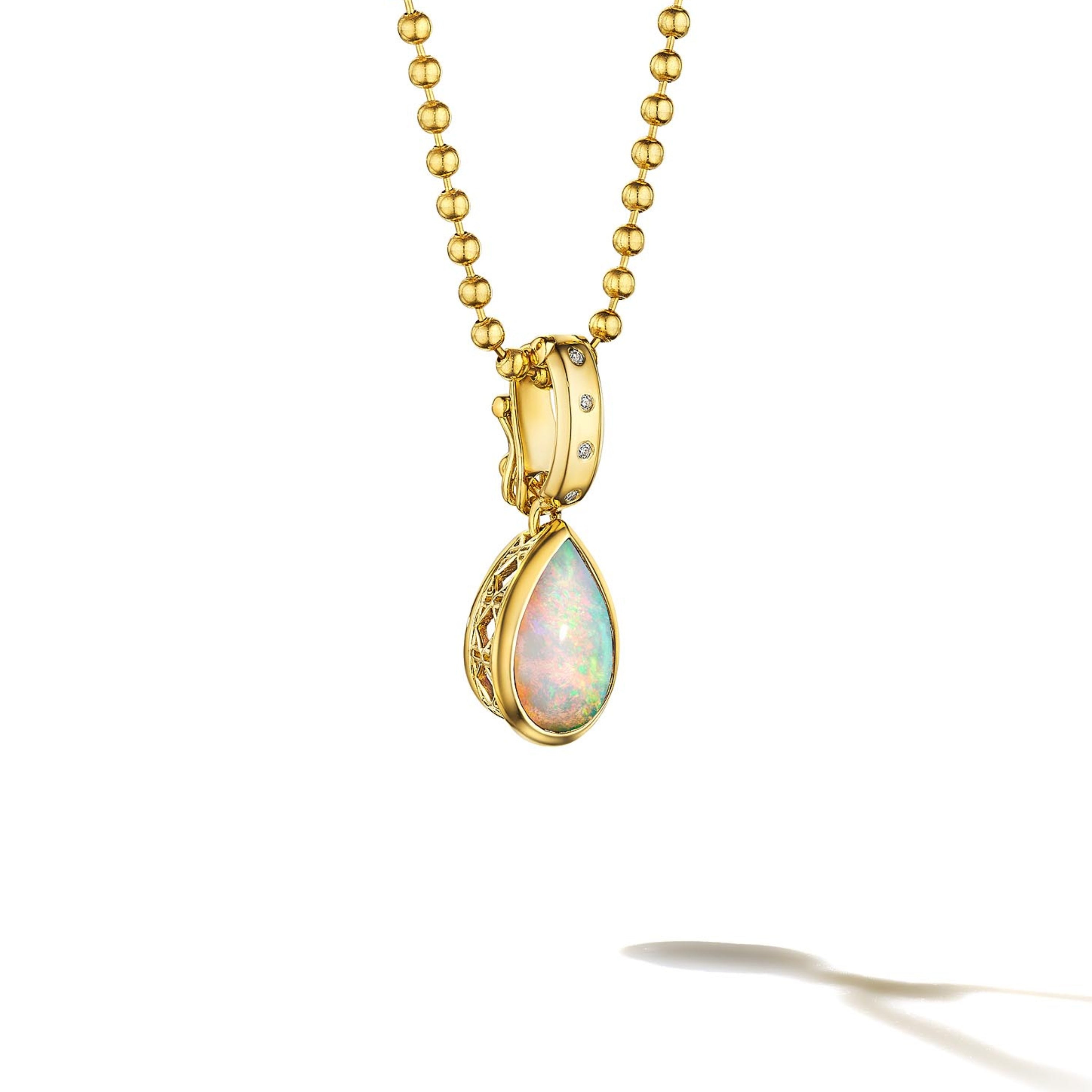 MoAnA LUU Dlo pear-shaped opal pendant in 18K yellow gold, featuring a cane-woven frame inspired by traditional Caribbean fish traps, reflecting the house’s vision of Creole-inspired fine jewelry crafted in New York.
