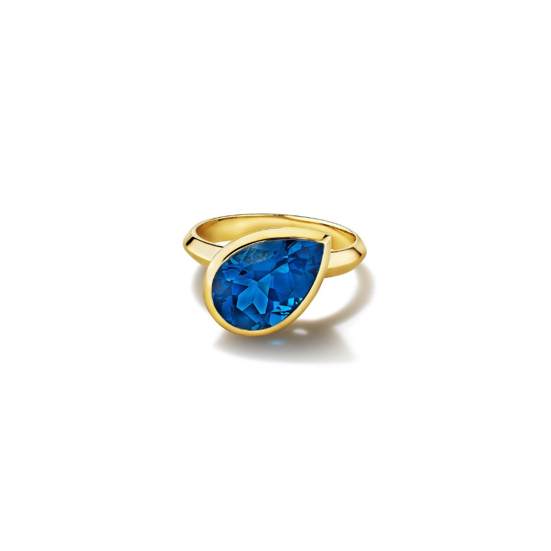MoAnA LUU Dlo pear-shaped london blue topaz ring in 18K yellow gold, featuring a cane-woven frame inspired by traditional Caribbean fish traps, reflecting the house’s vision of Creole-inspired fine jewelry crafted in New York.