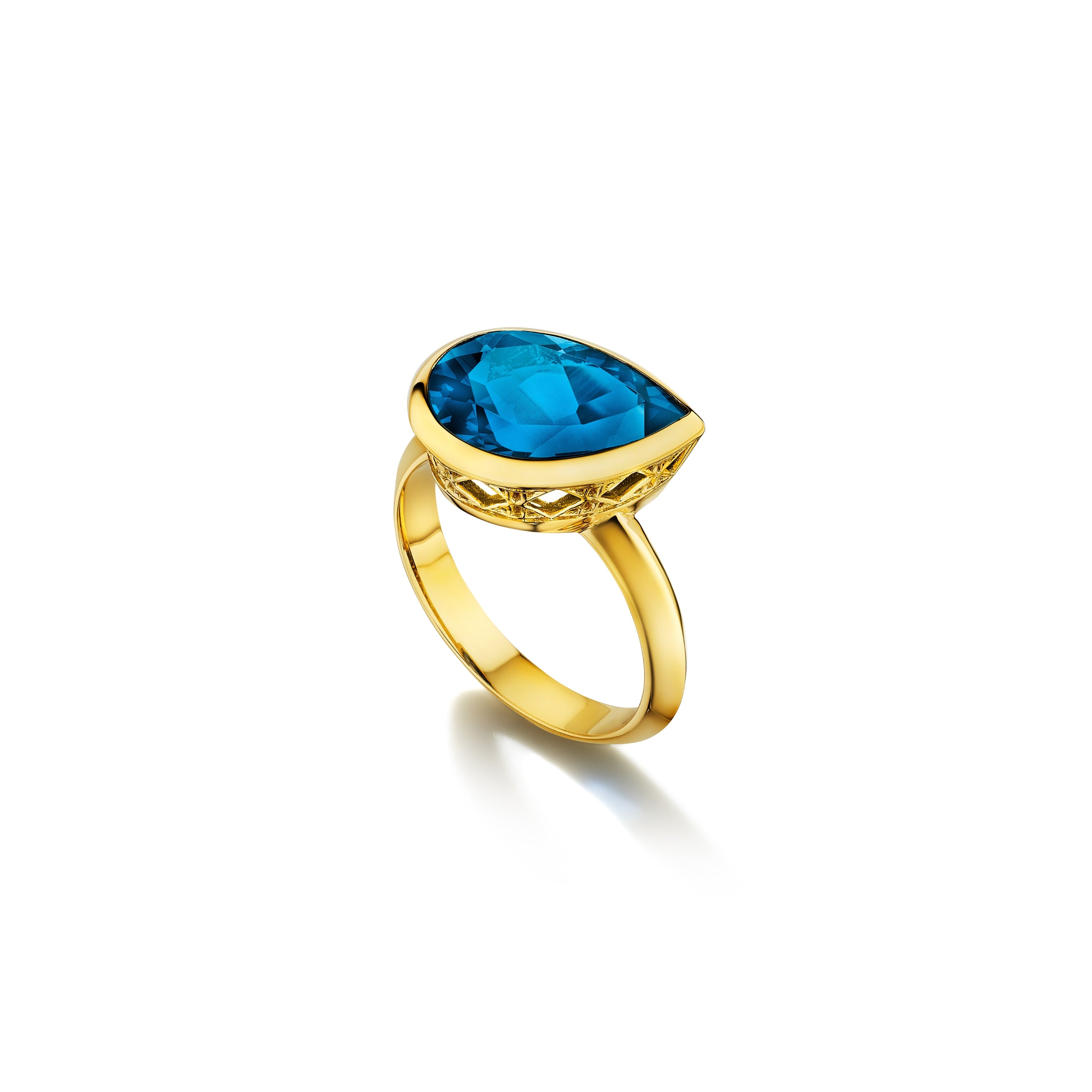 MoAnA LUU Dlo pear-shaped london blue topaz ring in 18K yellow gold, featuring a cane-woven frame inspired by traditional Caribbean fish traps, reflecting the house’s vision of Creole-inspired fine jewelry crafted in New York.