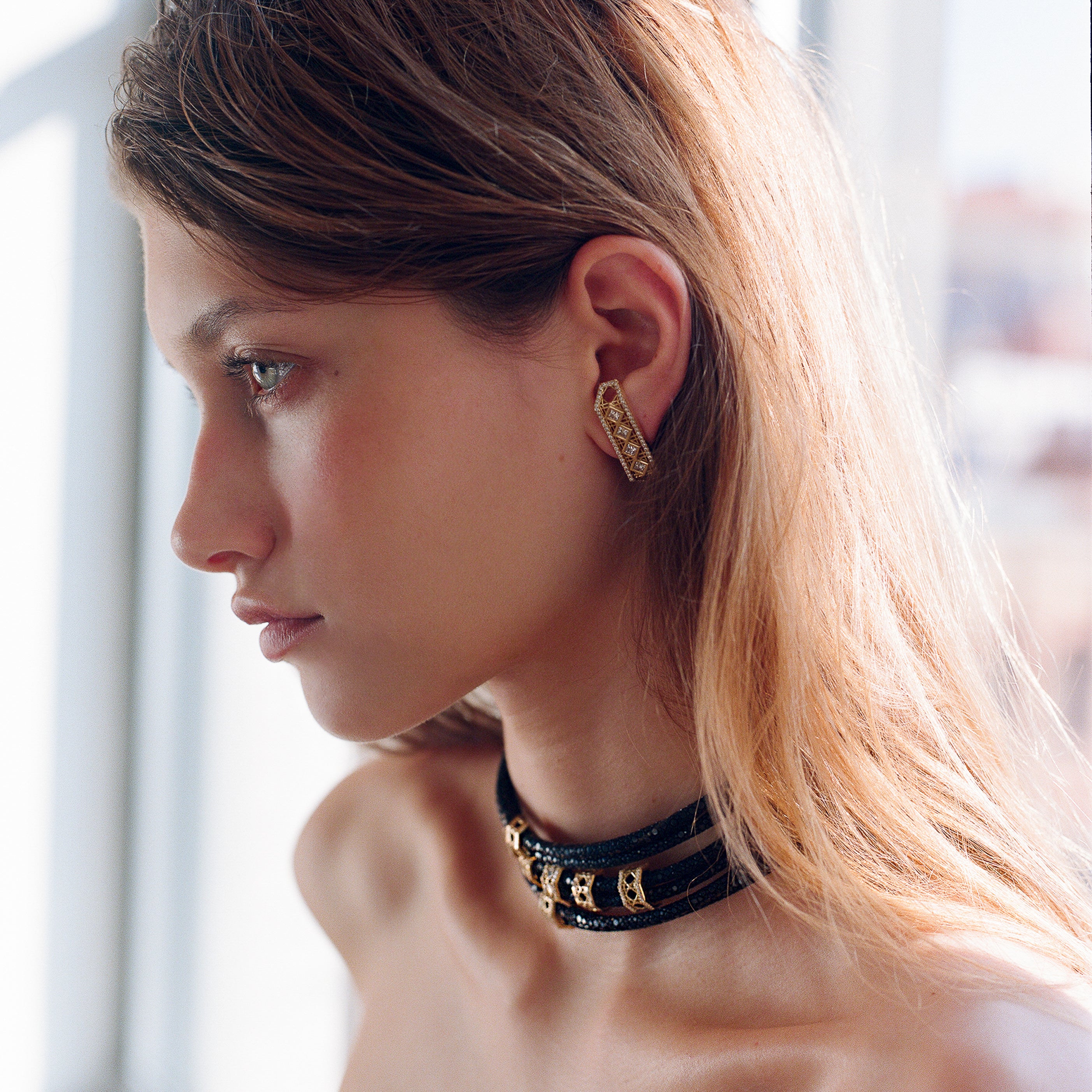 MoAnA LUU fine jewelry worn on model, featuring Abyss stingray leather chokers with 18K yellow gold elements and Doudou diamond cuff earrings with sculptural woven details inspired by Caribbean fish traps.