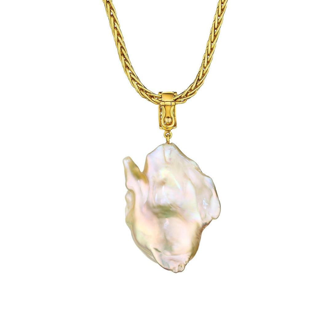 MoAnA LUU Abyss South Sea baroque pearl amulet in 18K yellow gold, featuring an oversized golden pearl pendant with diamond detail and signature cane-woven bail inspired by Caribbean fish traps.