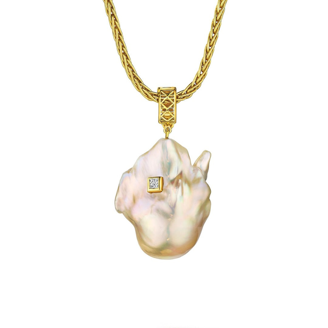 MoAnA LUU Abyss South Sea baroque pearl amulet in 18K yellow gold, featuring an oversized golden pearl pendant with diamond detail and signature cane-woven bail inspired by Caribbean fish traps.