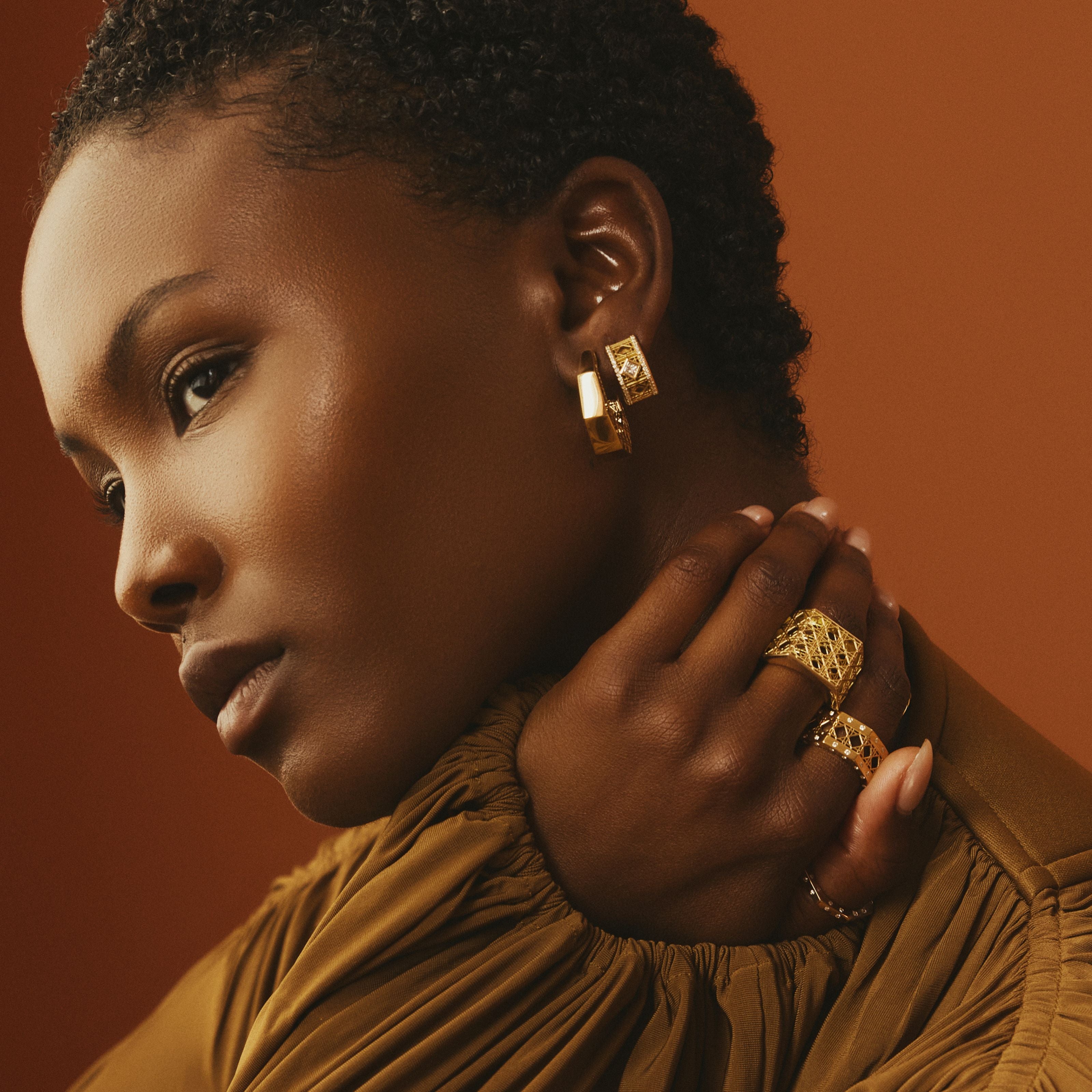 MoAnA LUU fine jewelry worn on model, featuring Doudou hoop earrings in 18K gold, paired with Doudou rings inspired by Creole craftsmanship.