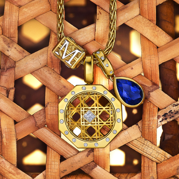 MoAnA LUU layered gold necklaces featuring Foyal monogram M bead, Doudou geometric pendant with diamond center, and Dlo pear-shaped blue sapphire charm on chain, set against woven cane inspired by Caribbean fish traps.