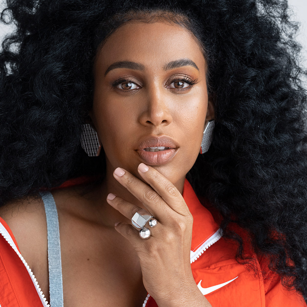 MoAnA LUU wearing MoAnA LUU ML open bead ring, embossed ring and statement octogonal earrings in silver, made in New York City. 