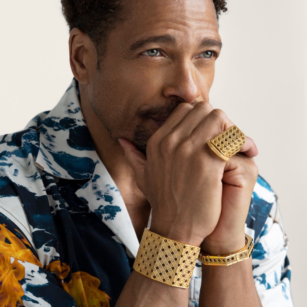 Gary Dourdan wearing MoAnA LUU Doudou maxi cuff, bracelet and maxi ring in 18K yellow gold,  cane-woven work inspired by traditional Caribbean fish traps, reflecting the house’s vision of Creole-inspired fine jewelry crafted in New York.