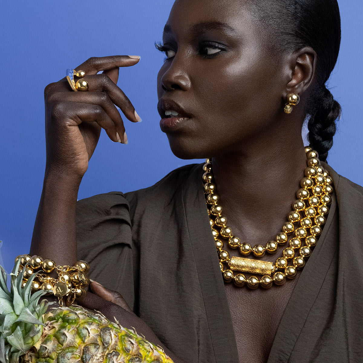 Model wearing MoAnA LUU beads necklace and ML open ring and earrings in vermeil inspired by Creole jewelry. 